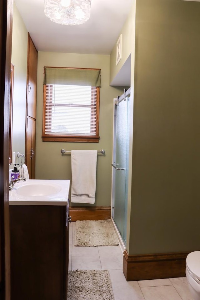 full bath featuring a shower with shower door, vanity, visible vents, and tile patterned floors