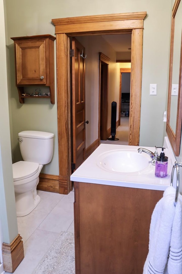 half bath with toilet, vanity, and tile patterned floors