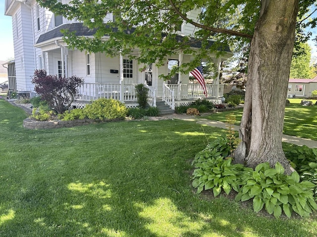 view of front facade featuring covered porch and a front yard