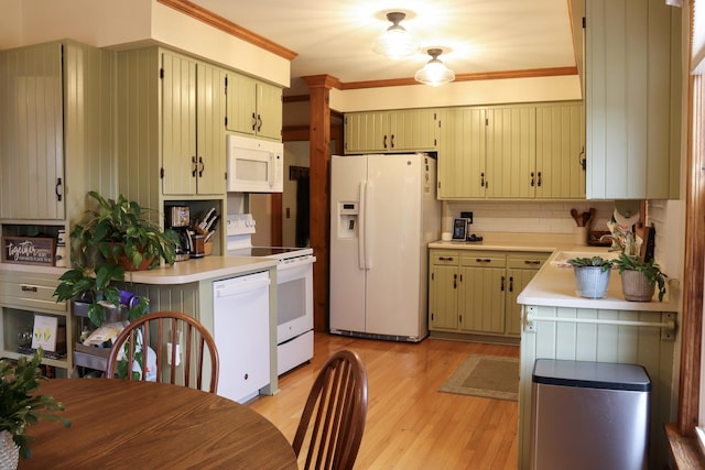 kitchen with white appliances, light wood-style floors, light countertops, ornamental molding, and backsplash