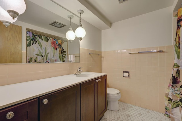 401 S Grove Ave Unit 2F, Oak Park, IL 60302 - full bath featuring tile walls, vanity, toilet, a wainscoted wall, and tile patterned floors