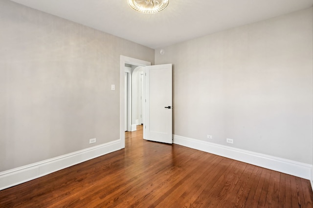 unfurnished room featuring baseboards and wood finished floors