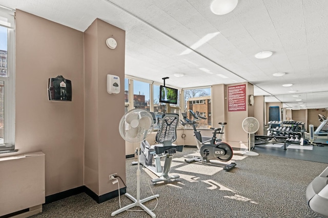 gym featuring radiator heating unit and baseboards