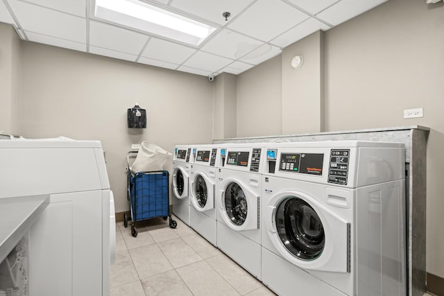 common laundry area with washing machine and clothes dryer and light tile patterned floors