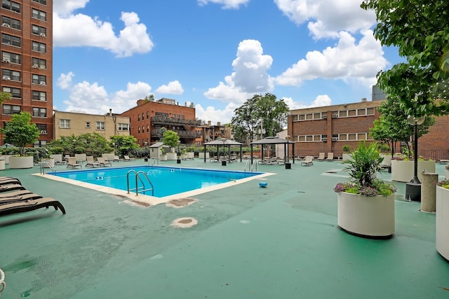 community pool featuring a gazebo, a patio area, and fence