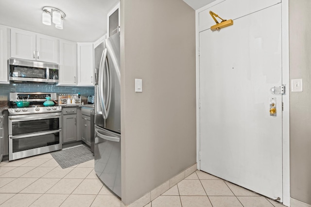 kitchen featuring gray cabinetry, tasteful backsplash, stainless steel appliances, light tile patterned flooring, and white cabinets