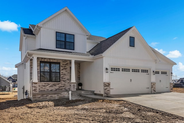 modern inspired farmhouse with a garage, brick siding, board and batten siding, and concrete driveway