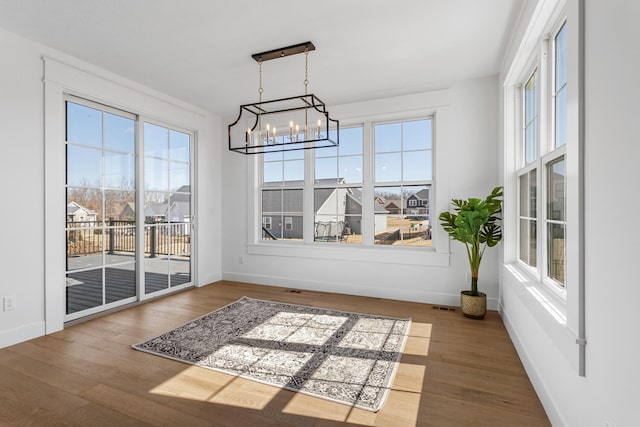 dining room with a residential view, an inviting chandelier, baseboards, and wood finished floors