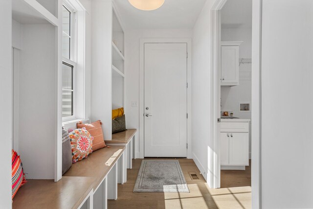 mudroom featuring light wood finished floors and visible vents