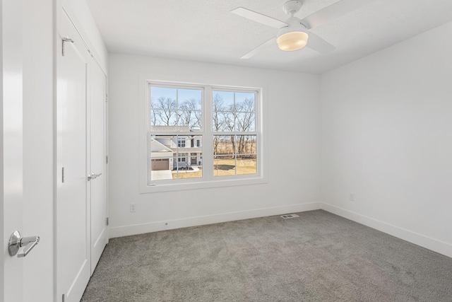 unfurnished bedroom with visible vents, a textured ceiling, carpet floors, baseboards, and ceiling fan