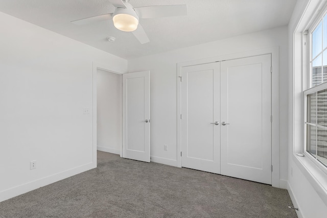 unfurnished bedroom with a closet, carpet flooring, a ceiling fan, and baseboards