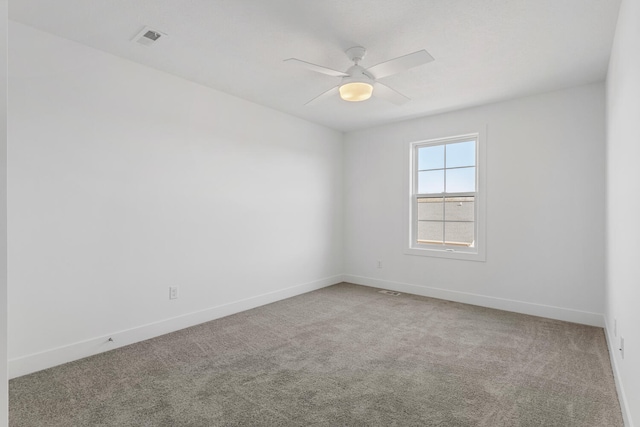 carpeted empty room with a ceiling fan, visible vents, and baseboards