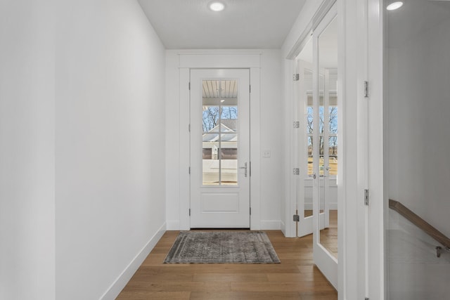 doorway to outside featuring baseboards and wood finished floors