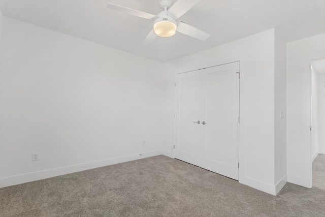 unfurnished bedroom with a closet, baseboards, ceiling fan, and carpet flooring