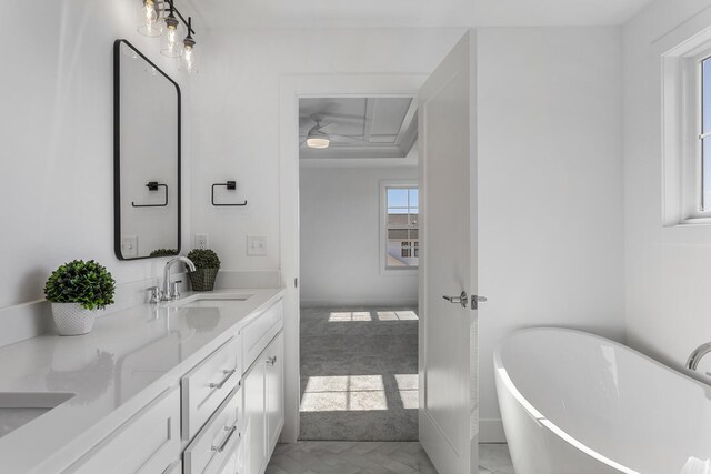 full bathroom with double vanity, a freestanding tub, and a sink