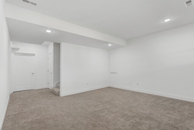 finished basement featuring visible vents, recessed lighting, stairs, and carpet