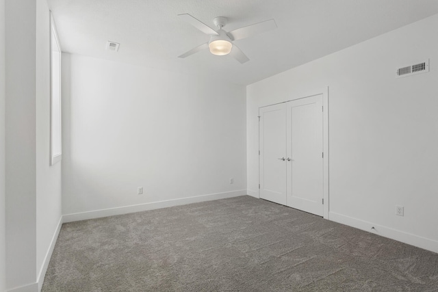 unfurnished bedroom with visible vents, a ceiling fan, baseboards, and carpet floors