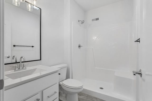 bathroom with visible vents, toilet, vanity, and walk in shower