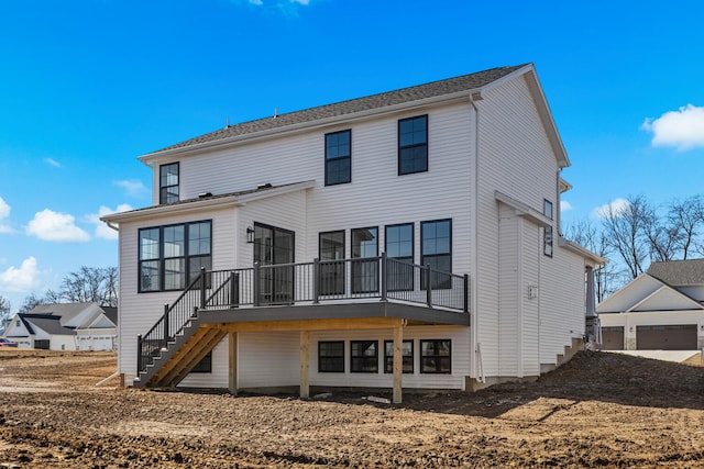 back of house featuring stairs, an outdoor structure, and a garage