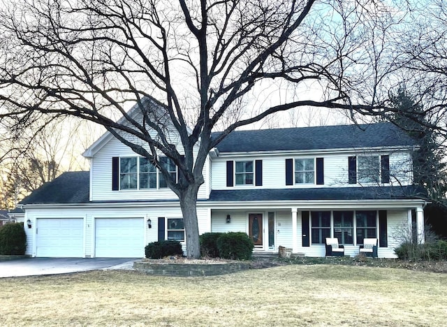 view of front of property featuring a front lawn, driveway, and roof with shingles