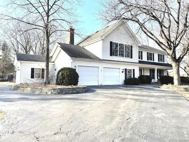 view of front of house featuring aphalt driveway and a chimney