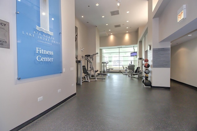 workout area featuring recessed lighting, visible vents, baseboards, and a towering ceiling