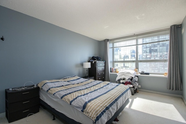 carpeted bedroom featuring baseboards and a textured ceiling