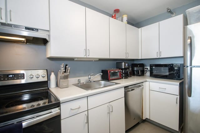 kitchen featuring light countertops, appliances with stainless steel finishes, under cabinet range hood, and a sink