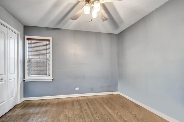 spare room featuring a ceiling fan, baseboards, and wood finished floors