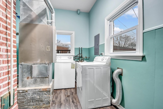 washroom with laundry area, electric panel, independent washer and dryer, and wood finished floors