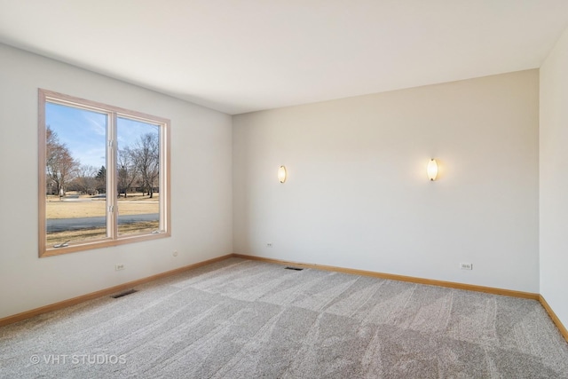 empty room with visible vents, baseboards, and light colored carpet