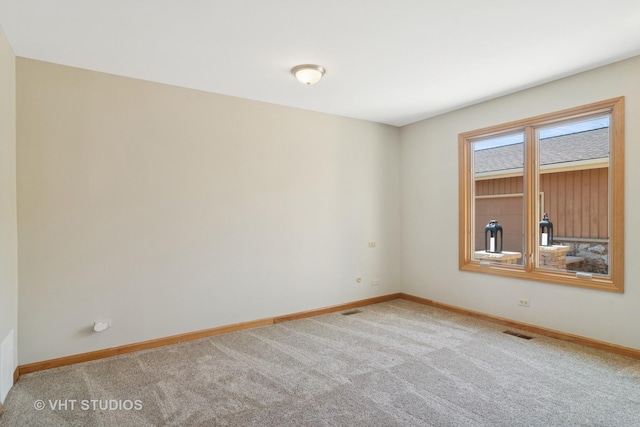 empty room with visible vents, carpet floors, and baseboards