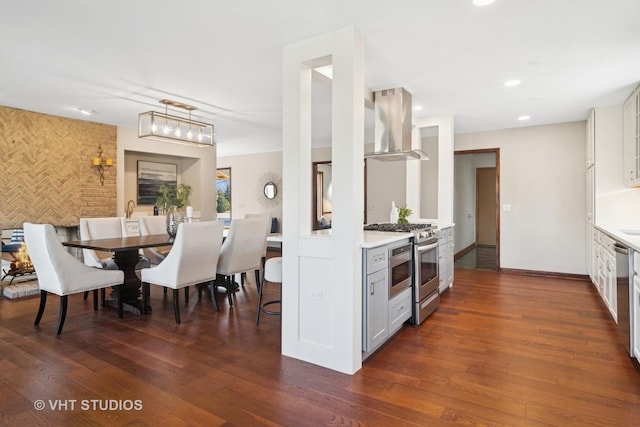 kitchen featuring an accent wall, extractor fan, wood finished floors, and light countertops