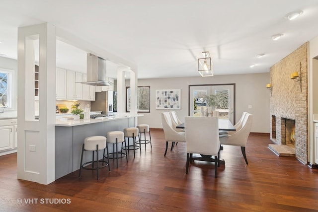 dining room with a fireplace and dark wood-style flooring