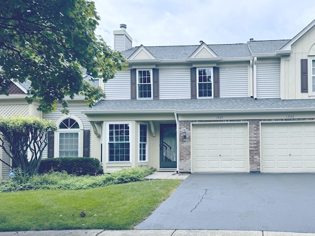 view of front of property featuring a garage, brick siding, a shingled roof, driveway, and a chimney