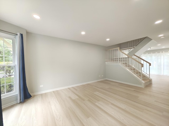 unfurnished room with light wood-style floors, stairs, baseboards, and recessed lighting