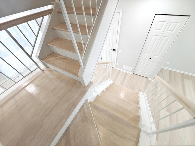 staircase with wood finished floors and visible vents