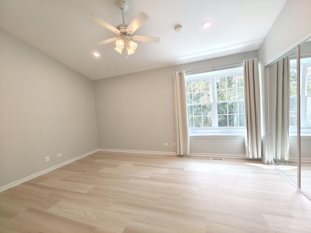 unfurnished room featuring light wood finished floors, plenty of natural light, and baseboards