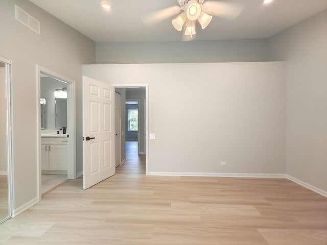 unfurnished bedroom with ensuite bath, light wood-style floors, baseboards, and visible vents