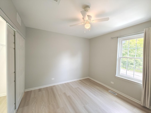 unfurnished bedroom featuring visible vents, baseboards, a ceiling fan, light wood-style flooring, and a closet