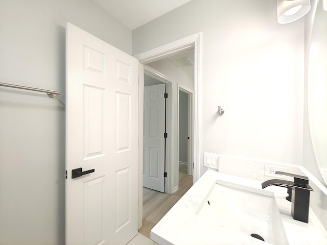 bathroom with visible vents, a sink, and wood finished floors