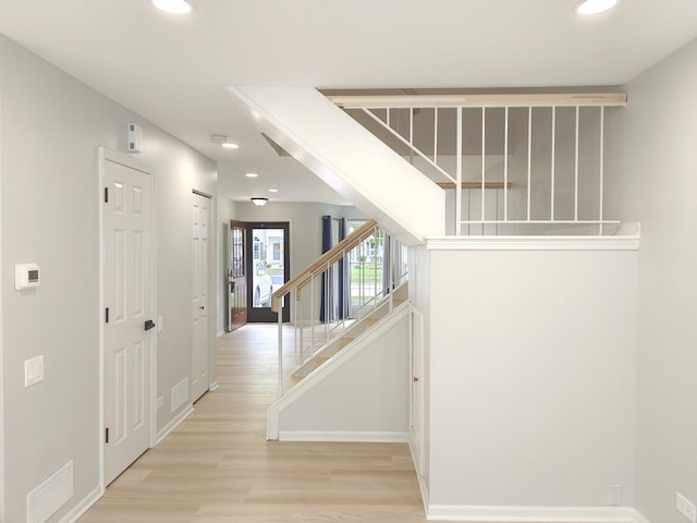 hallway featuring recessed lighting, visible vents, light wood-style flooring, and stairs