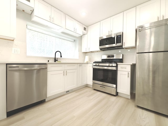 kitchen featuring white cabinetry, stainless steel appliances, and light countertops