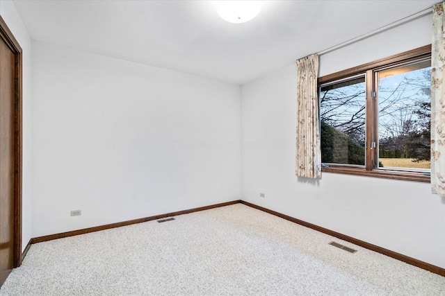 unfurnished room with baseboards, visible vents, and carpet flooring