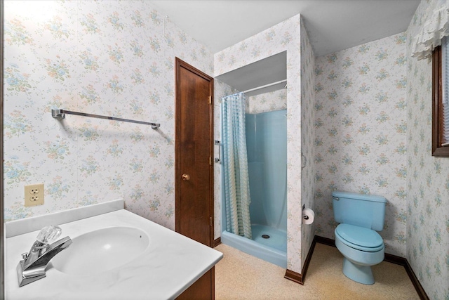 bathroom with toilet, wallpapered walls, vanity, and a stall shower