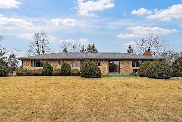 single story home with brick siding, a chimney, and a front lawn