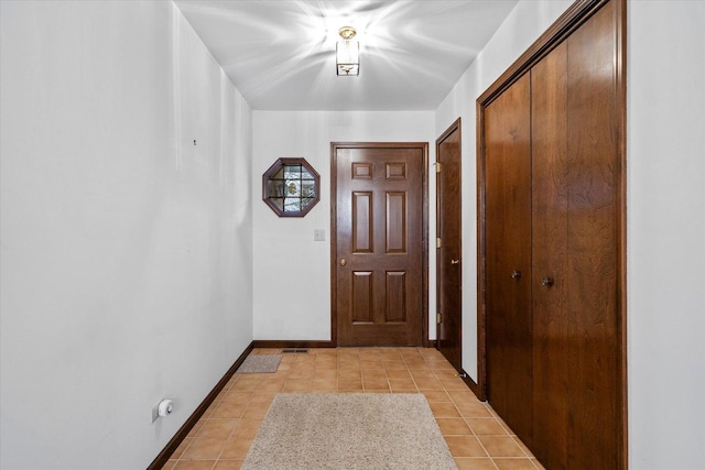 entryway with light tile patterned floors and baseboards