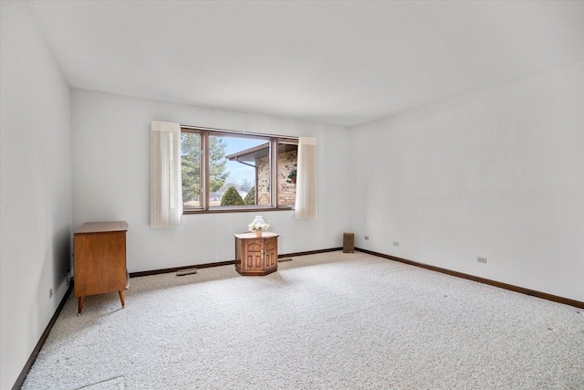 carpeted empty room with visible vents and baseboards