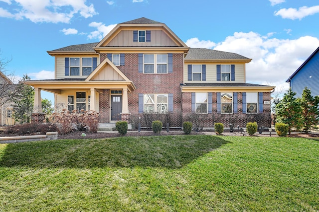 view of front of property featuring brick siding, board and batten siding, covered porch, and a front yard