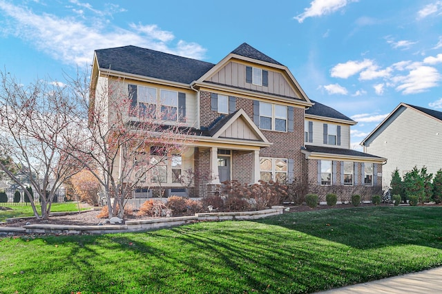 view of front of home with a front yard, a porch, brick siding, and board and batten siding